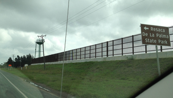The border fence along a highway.